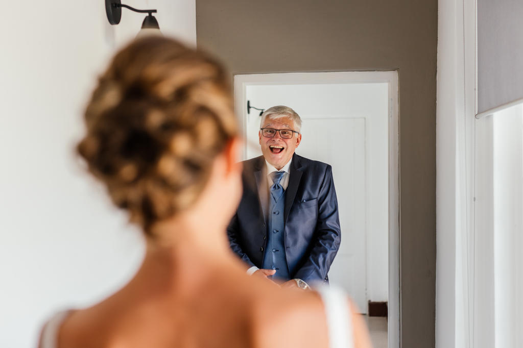 A family member beaming as he sees the bride in her dress