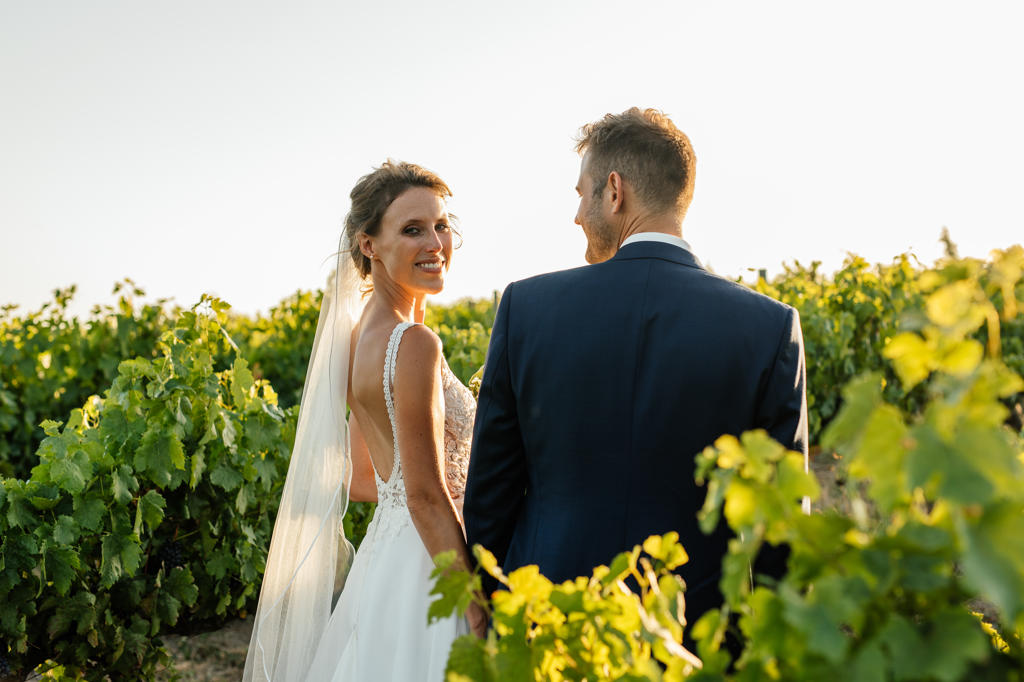 Bride and groom looking out over a vineyard
