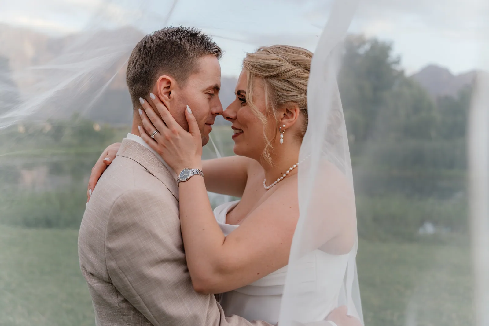 Henry and Kathrin kissing beneath her veil in the late afternoon light