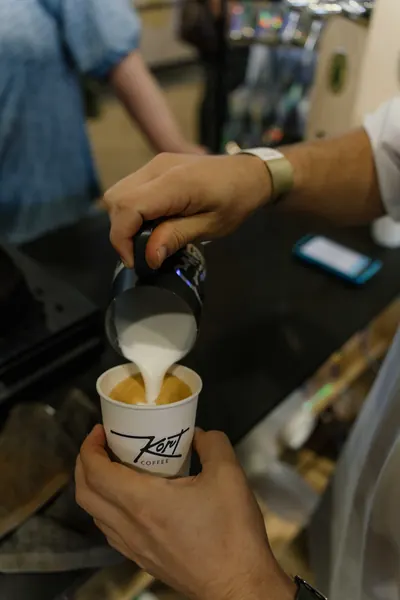 Milk poured into a flat white at the stand, Kort Coffee
