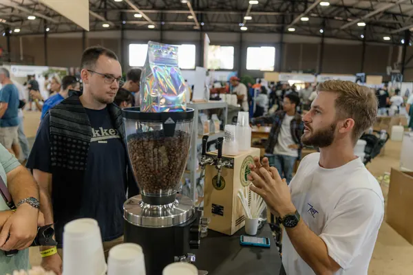 The barista in his Kort Koffie shirt serving customers, Kort Coffee