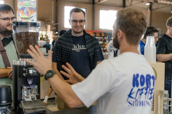 The barista in his Kort Koffie shirt serving customers, Kort Coffee