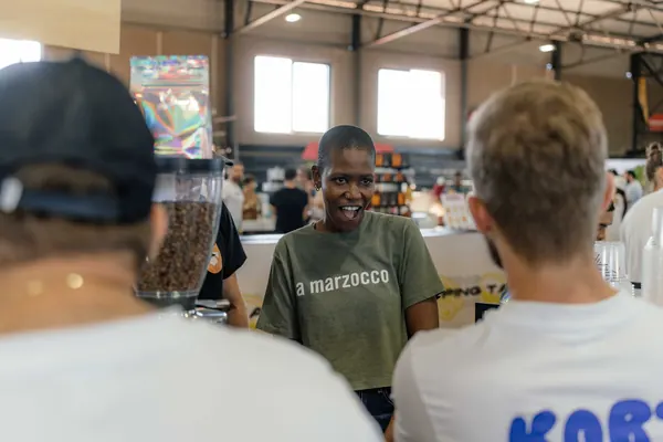 The Kort Koffie shirt from behind as the barista serves, Kort Coffee