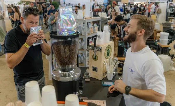 A customer smelling the coffee across the counter