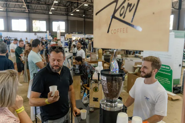 A crowd at the Kort Coffee stand under the sign