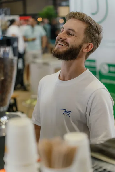 The barista smiling behind the counter